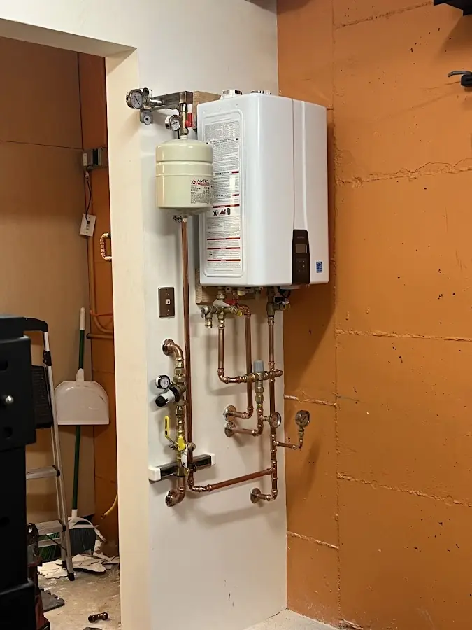 Plumbing technician inspecting water heater connections in Catskill